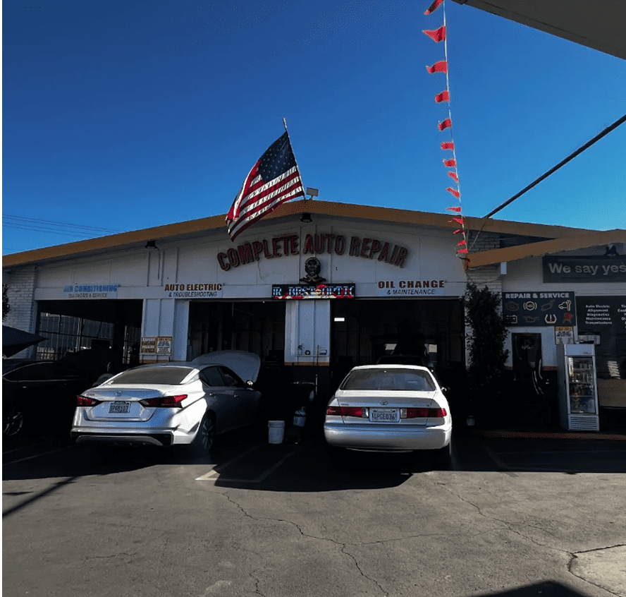 Auto repair shop with parked cars outside.