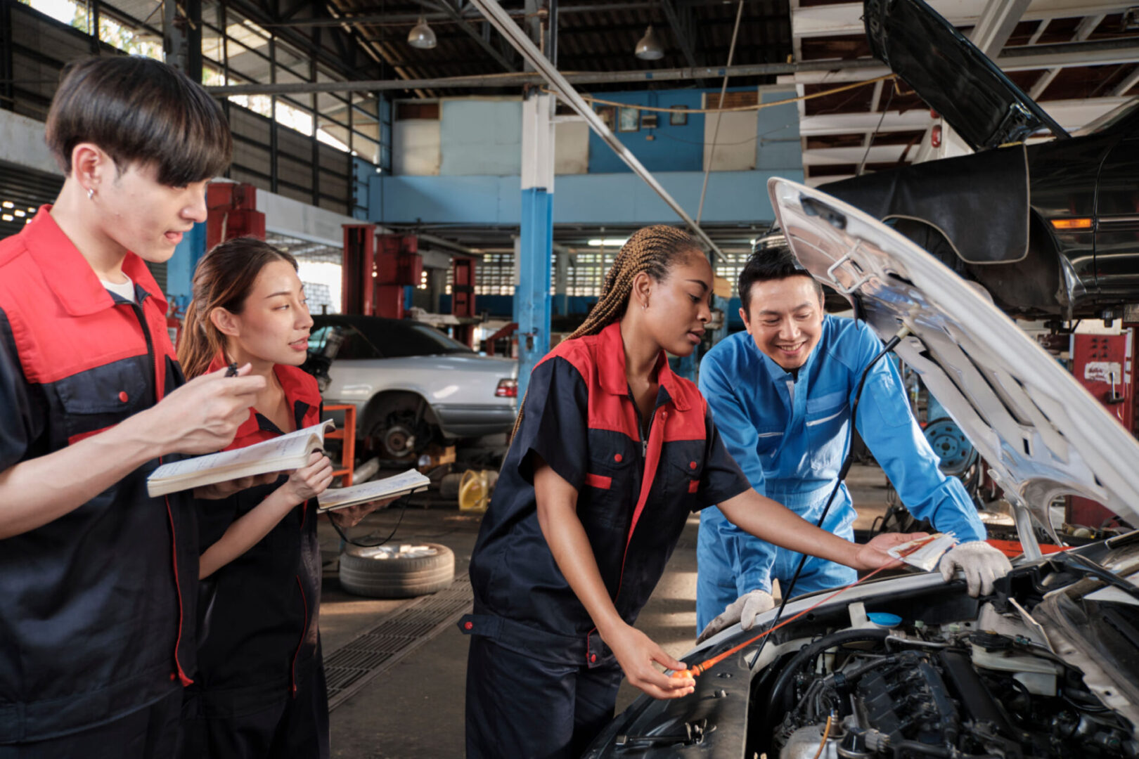 Mechanics collaborating on car engine inspection.